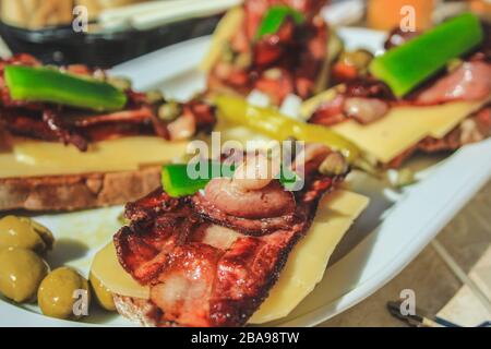 Tapas tradizionali spagnole con pancetta e formaggio sul pane Foto Stock