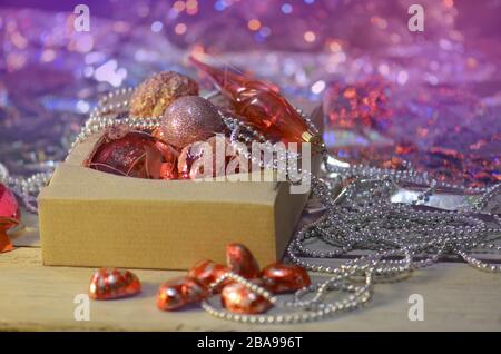 Scatola con molte decorazioni di Natale. Immagine in stile retrò della decorazione di Natale. Composizione di Natale con scatola Foto Stock