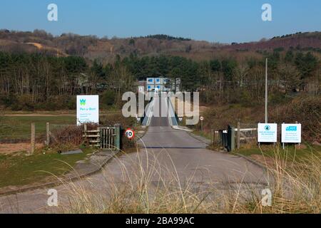 La strada di accesso a Bridgend (Pen Y Bont) foul acqua trattamento opere situato in Merthyr Mawr dune di sabbia tra alberi piantati screening. Foto Stock