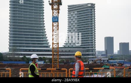 (200326) -- WUHAN, 26 marzo 2020 (Xinhua) -- i lavoratori osservano i progressi in un cantiere in Wuhan, provincia di Hubei della Cina centrale, 26 marzo 2020. Un progetto a Wuhan intrapreso dalla China Construction Third Engineering Bureau Co., Ltd ha ripreso ufficialmente i lavori mercoledì. Attualmente, più di 400 manager e lavoratori sono tornati nel cantiere e più di 500 lavoratori torneranno a lavorare la prossima settimana. Il 25 marzo, l'applicazione della ripresa della costruzione è stata approvata dalla sede di controllo COVID-19 della Wuhan East Lake High-tech Development zone dopo str Foto Stock