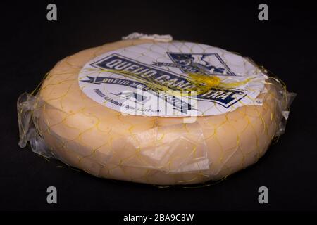 Confezionato in plastica mantenibile Canasta tradizionale brasiliano formaggio [Queijo Canastra] confezionato in plastica mantenibile su una superficie scura Foto Stock