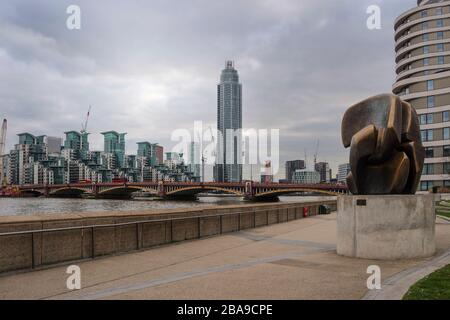 Scultura in bronzo "pezzo di bloccaggio" con Riverwalk Apartment e St George Wharf sullo sfondo del fiume Tamigi, Londra, Regno Unito Foto Stock