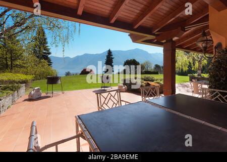 veranda di una villa con giardino in una soleggiata giornata primaverile Foto Stock