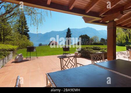 veranda di una villa con giardino in una soleggiata giornata primaverile Foto Stock