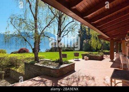 veranda di una villa con giardino in una soleggiata giornata primaverile Foto Stock