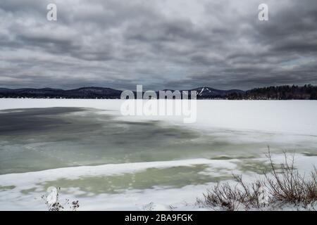 Tranquillo paesaggio di montagna e lago ghiacciato nelle montagne Adirondack dello stato di New York Foto Stock