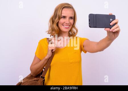 Ritratto di felice bella donna turistica bionda con zaino prendere selfie Foto Stock