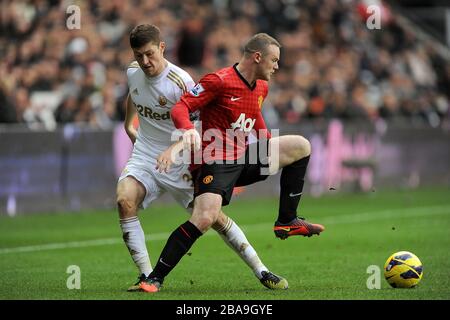 Ben Davies (a sinistra) di Swansea City e Wayne Rooney (a destra) di Manchester United combattono per la palla Foto Stock