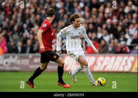Jonny Evans del Manchester United (a sinistra) e Miguel Michu della Swansea City (a destra) combattono per la palla Foto Stock