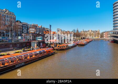 Gruppo di imbarcazioni per tour vuote ad Amsterdam nei Paesi Bassi a causa dell'epidemia di coronavirus Foto Stock