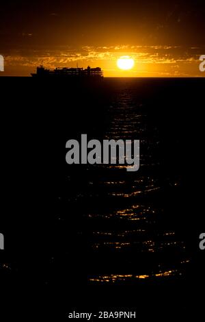 Una crociera ancorò i terreni offshore in un epico tramonto rosso sangue. Australia occidentale Foto Stock