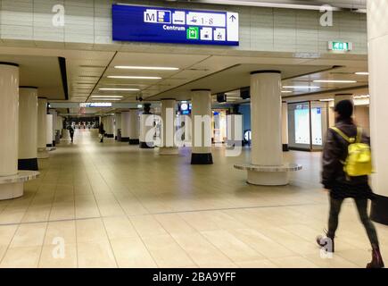 Amsterdam, Olanda 25 marzo 2020 : UN passeggero fa un giro attraverso le sale quasi deserte della Stazione Centrale durante l'ora di punta. Risultato diretto di misure più severe da parte del governo olandese per combattere la crisi del 19. Foto Stock