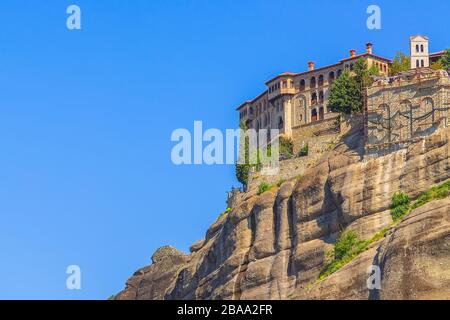 Vista del monastero ortodosso di Varlaam a Meteora, Grecia, su roccia alta e cielo blu sullo sfondo Foto Stock