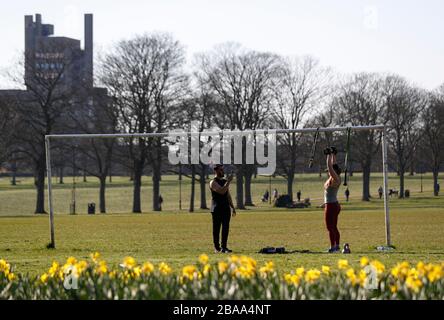 Leicester, Leicestershire, Regno Unito. 26 marzo 2020. Un esercizio di coppia sotto un paletto a Victoria Park a Leicester durante la pandemia di Coronavirus. Credit Darren Staples/Alamy Live News. Foto Stock