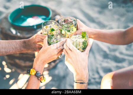 I migliori amici gustano cocktail. I giovani bevono all'aperitivo. Profondità di campo bassa con attenzione agli amici aggraffatura a mano con bicchiere per succo. Foto Stock