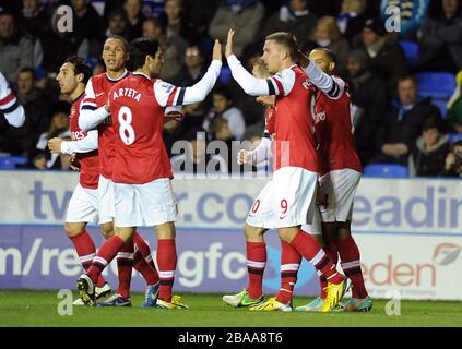 Lukas Podolski dell'Arsenal (a destra) celebra il raggiungimento dell'obiettivo di apertura del gioco con i suoi compagni di squadra Foto Stock