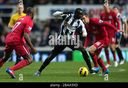 Papiss Cisse (al centro) e James McArthur (a destra) di Wigan Athletic si battono per la palla Foto Stock