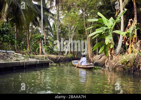 Donna a canottaggio su barca singola a Bali Foto Stock