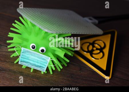 Figura del virus con maschera sotto flyswatter, foto simbolica Coronavirus e infezioni del virus, Virus-Figur mit Mundschutz unter Fliegenklatsche, Symbolfoto Foto Stock