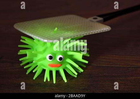 Figura del virus con flyswatter, foto simbolica Coronavirus e infezioni del virus, Virus-Figur mit Fliegenklatsche, Symbolfoto Coronavirus und Virusinfekt Foto Stock