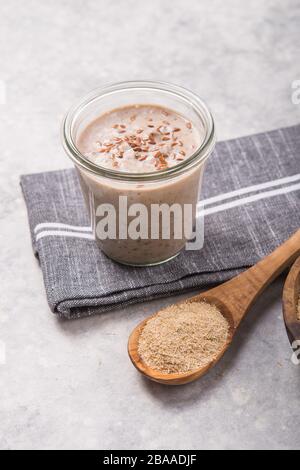 Bevanda vegana non casearia, con crusca di avena su fondo bianco in cemento. Mangiare sano Foto Stock