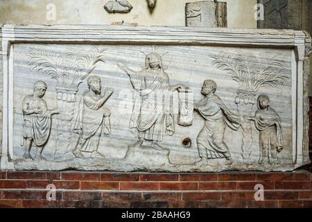 Italia - Emilia Romagna - Ravenna - Museo Nazionale - sarcofago della Traditio Legis in marmo proconnesiano ispirato, sia per il motivo trattato che per la struttura architettonica, da modelli di Costantinopoli. Il sarcofago, privo della copertina originale e di uno dei due lati lunghi, può essere datato al primo quarto del V secolo. Sul fronte la composizione è dominata dalla figura di Cristo con nimbus monogramma e ricoperta di tunica e pallio. Alla destra di Cristo c'è l'apostolo Paolo che eleva il braccio destro in giubilazione. Foto Stock