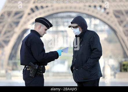 Parigi, Francia. 26 marzo 2020. Le forze di sicurezza mantengono le loro distanze per proteggersi da una potenziale infezione mentre controllano i residenti per i documenti che consentono loro di essere nelle strade di Parigi, Francia, 26 marzo 2020. Le autorità francesi hanno reso più severe le norme di blocco sull'esercizio fisico, limitando oggi le uscite a un massimo di un'ora, poiché l'epidemia di coronavirus continua a diffondersi nel paese con 1,331 morti, di cui 186 nelle ultime 24 ore. Foto di Eco Clement/UPI Credit: UPI/Alamy Live News Foto Stock