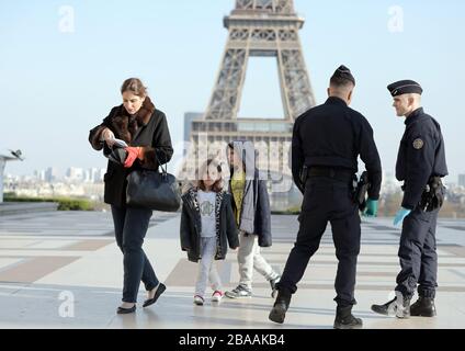 Parigi, Francia. 26 marzo 2020. Le forze di sicurezza mantengono le loro distanze per proteggersi da una potenziale infezione mentre controllano i residenti per i documenti che consentono loro di essere nelle strade di Parigi, Francia, 26 marzo 2020. Le autorità francesi hanno reso più severe le norme di blocco sull'esercizio fisico, limitando oggi le uscite a un massimo di un'ora, poiché l'epidemia di coronavirus continua a diffondersi nel paese con 1,331 morti, di cui 186 nelle ultime 24 ore. Foto di Eco Clement/UPI Credit: UPI/Alamy Live News Foto Stock