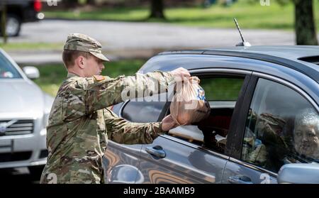 I soldati della Guardia Nazionale della Virginia Occidentale distribuiscono pasti preparati per più di 3,600 studenti in età scolare in tutta la Contea di Greenbrier a sostegno del COVID-19, ordini di quarantena per il coronavirus il 25 marzo 2020 a Lewisburg, Virginia Occidentale. Foto Stock