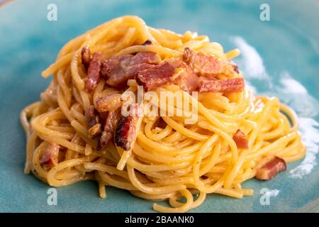spaghetti alla carbonara su un piatto blu Foto Stock