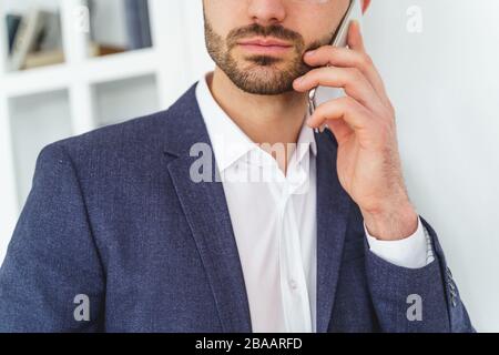 Uomo caucasico bearded che fa una chiamata telefonica Foto Stock