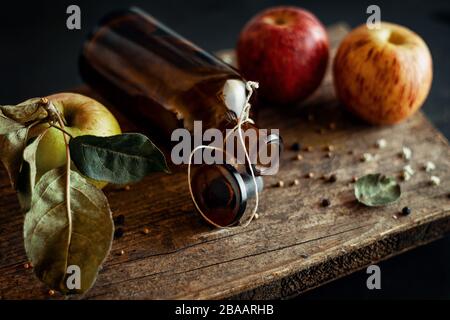 Bottiglia decorata con frutta su vecchio piatto di legno Foto Stock