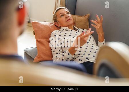 Paziente femmina depresso sdraiato su un divano Foto Stock