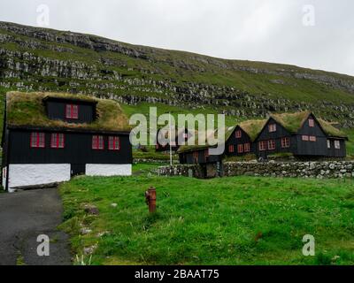 Isole Faroe. Case tradizionali con tetti in erba del villaggio di Kirkjubøur. Foto Stock