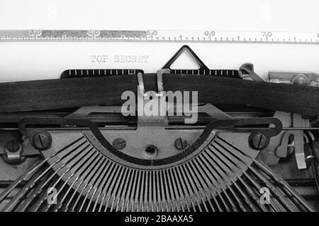 Vecchia macchina da scrivere retrò vintage. Un foglio bianco con il testo stampato top secret.in bianco e nero Foto Stock