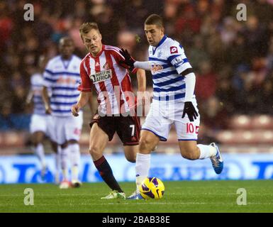 Sebastian Larsson di Sunderland e Adel Taarabt di Queens Park Rangers si battono per la palla Foto Stock