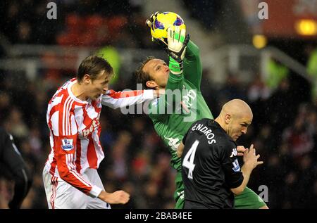 Il portiere di Fulham, Mark Schwarzer (al centro), salva dalla testa di Peter Crouch (a sinistra) di Stoke City Foto Stock