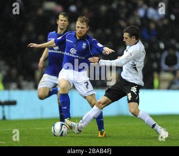 Craig Bryson della Derby County (a destra) sfida Christopher Burke (al centro) di Birmingham City per il pallone. Foto Stock