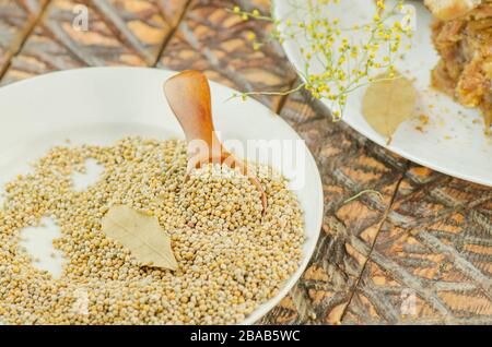 Senape in ciotola su sfondo di legno. È usato in nutrizione sana, cosmetica, medicina Foto Stock