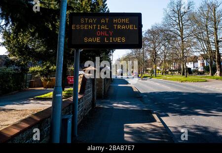 Firma, soggiorno a casa, viaggio essenziale solo, salvare vite, segnale di traffico, riproposto per l'avvertimento di salute pubblica, Caversham, Reading, Berkshire, Inghilterra, Regno Unito. Foto Stock