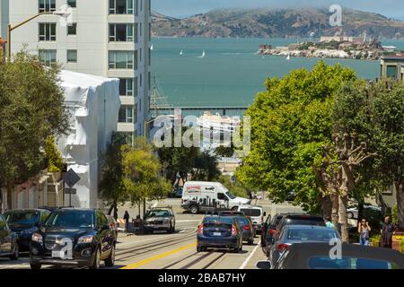 San Francisco, California, USA - 07 Giugno 2015: Elegante facciata della cittadina e parcheggiate le auto sulla famosa ripida Lombard Street. San Francisco Bay in the ba Foto Stock