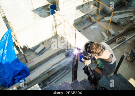 Vista ad angolo elevato della saldatura manuale in cantiere. Foto Stock