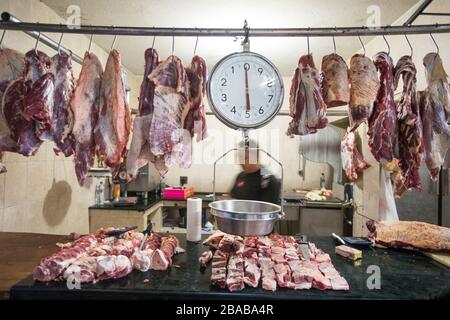 Carne e pesare la bilancia appesa in una macelleria Foto Stock