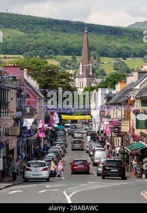 Vista del traffico automobilistico sulla trafficata Henry Street e la chiesa di Santa Croce in Kenmare County Kerry Irlanda Foto Stock