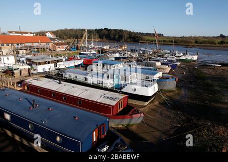 Chiatte e una varietà di vivere a bordo di case galleggianti ormeggiate al Ferry Quay, fiume Deben, Woodbridge, Suffolk, Inghilterra, Regno Unito Foto Stock