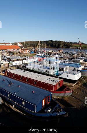 Chiatte e una varietà di vivere a bordo di case galleggianti ormeggiate al Ferry Quay, fiume Deben, Woodbridge, Suffolk, Inghilterra, Regno Unito Foto Stock