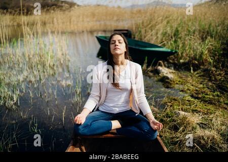 Donna meditando in natura.fuga da stressante reality.memore donna praticante meditation.Breathing technique.Mental state issues menagement. Foto Stock