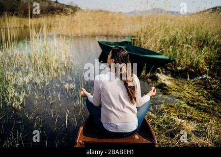 Donna meditando in natura.fuga da stressante reality.memore donna praticante meditation.Breathing technique.Mental state issues menagement. Foto Stock