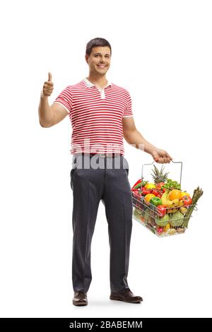 Ritratto a tutta lunghezza di un giovane sorridente con frutta e verdura in un cestino isolato su sfondo bianco Foto Stock