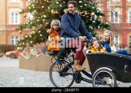 Giovane famiglia a cavallo in bicicletta da carico insieme Foto Stock